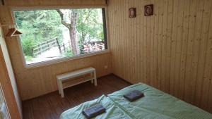 a bedroom with a bed and a window and a bench at Mill Hause Apart 1 in Druskininkai