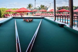 a pool table at a resort with red umbrellas at First Group La Cote D'Azur in Margate