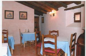 uma sala de jantar com duas mesas e uma mesa e cadeiras azuis em Parada del Carmen em Albarracín