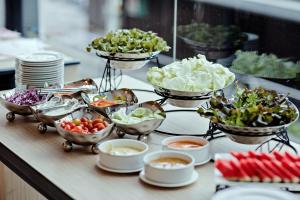 a buffet line with bowls of vegetables and other dishes at Three Sukhumvit Hotel - SHA Plus Certified in Bangkok +68 photos