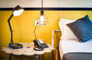 a telephone on a table next to a bed at Teku Sardinia Boutique Hotel in Bari Sardo