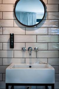 a bathroom with a white sink and a mirror at Teku Sardinia Boutique Hotel in Bari Sardo