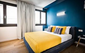 a bedroom with a bed with a blue wall at Teku Sardinia Boutique Hotel in Bari Sardo