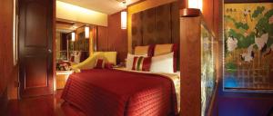um quarto com uma cama com um cobertor vermelho em Spring Breeze Boutique Motel em Kaohsiung