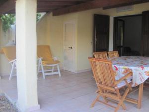 a porch with a table and chairs on a patio at casa vacanza in San Teodoro