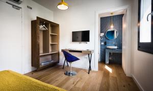 a room with a desk and a blue chair at Teku Sardinia Boutique Hotel in Bari Sardo