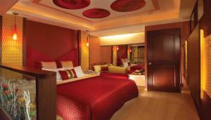 a bedroom with a red bed and a living room at Spring Breeze Boutique Motel in Kaohsiung