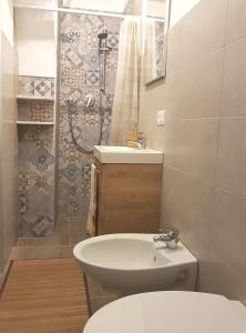 Un baño con inodoro, lavabo y ducha. en Casa Eleonora, en Monopoli