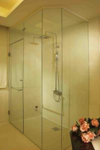 a glass shower in a bathroom with pink roses at Spring Breeze Boutique Motel in Kaohsiung