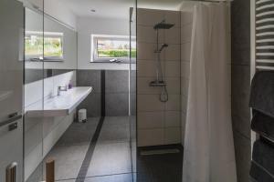 a bathroom with a shower and a sink and a shower curtain at Selke´s exklusives Ferienhaus in Clausthal-Zellerfeld +23 photos