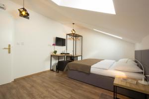 1 dormitorio con 1 cama grande y 1 mesa en Riverside Residence en Sarajevo