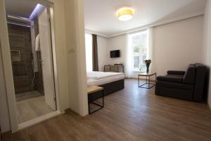 1 dormitorio con cama, ducha y sofá en Riverside Residence, en Sarajevo