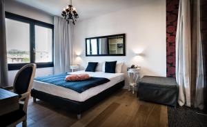 a bedroom with a bed and a chair and a mirror at Teku Sardinia Boutique Hotel in Bari Sardo