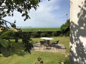 a table and chairs in a yard with a view of the ocean at Langø Sea View in Langø