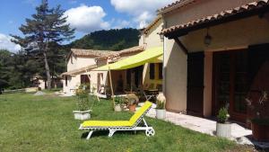 żółtą ławkę na podwórku domu w obiekcie Clos de l'Artuby w mieście Valderoure