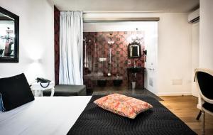 a room with a bed with a pillow on it at Teku Sardinia Boutique Hotel in Bari Sardo