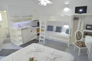 um quarto branco com 2 beliches e um lavatório em Moschoula Studios em Adamas