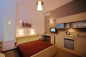 a bedroom with a bed and a desk and a sink at Platinium Centrum in Wrocław