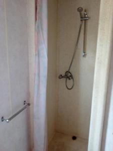 łazienka z prysznicem z zasłoną prysznicową w obiekcie Domki Gucio i Maja w mieście Grodzisk Mazowiecki