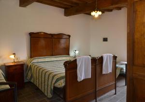 a bedroom with a bed with a wooden headboard at Villa Pascolo in Costacciaro