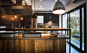 a kitchen with a counter with two sinks in it at Teku Sardinia Boutique Hotel in Bari Sardo