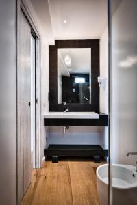 a bathroom with a sink and a mirror at Teku Sardinia Boutique Hotel in Bari Sardo