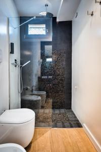 a bathroom with a shower with a toilet and a sink at Teku Sardinia Boutique Hotel in Bari Sardo