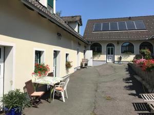 a courtyard of a house with a table and chairs at Gästehaus Lindenhof in Jennersdorf