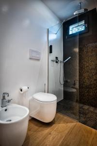 a bathroom with a toilet and a glass shower at Teku Sardinia Boutique Hotel in Bari Sardo
