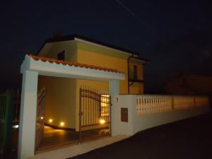a small house with a gate at night at Villa Stella in Praia a Mare +14 photos