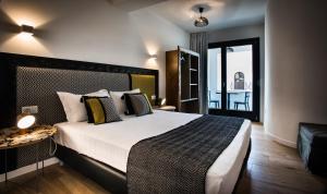 a bedroom with a large bed and a balcony at Teku Sardinia Boutique Hotel in Bari Sardo