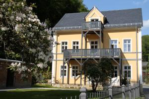 Una casa amarilla con balcón en la parte superior. en Villa Elise, en Bad Schandau