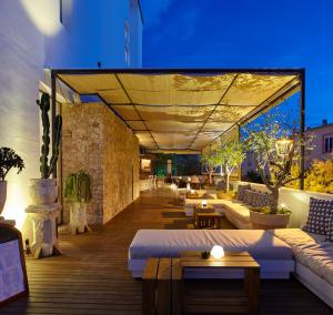 an outdoor patio with couches and tables at Apartamentos Castaví in Es Pujols
