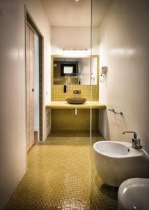 a bathroom with a tub and a sink and a mirror at Teku Sardinia Boutique Hotel in Bari Sardo
