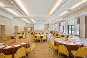 a large room with tables and chairs and a whiteboard at Starhotels Grand Milan in Saronno