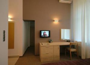 Habitación con escritorio y espejo en la pared. en Platinium Centrum en Wroclaw