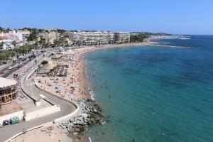 an aerial view of a beach with people and the ocean at Coeur de Fréjus, L'AMPHITHÉÂTRE, appartement 3 pièces climatisé, terrasse, barbecue, piscine & parking in Fréjus
