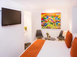 a bedroom with a bed and a flat screen tv at Almijara Residence in Cómpeta