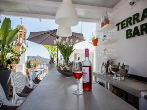 a bottle of wine sitting on a table with a glass at Almijara Residence in Cómpeta