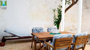 een houten tafel en stoelen op een terras bij Borgo Guesthouse in Monopoli +31 foto's