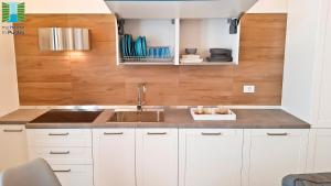 een keuken met witte kasten en een spoelbak bij Borgo Guesthouse in Monopoli