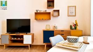 een woonkamer met een tv op een houten entertainmentcentrum bij Borgo Guesthouse in Monopoli