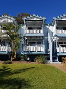 a large white house with a blue roof at Moreton Island Villas and Apartments in Tangalooma