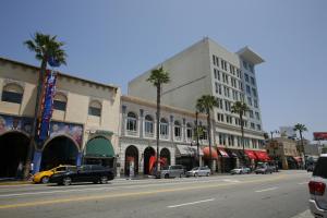 una calle de la ciudad con coches estacionados frente a los edificios en Hollywood Guest Inn, en Los Ángeles