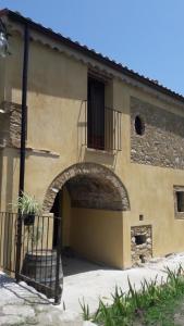 GuardavalleにあるAgriturismo Villa Vittoriaのアーチとバルコニー付きの建物