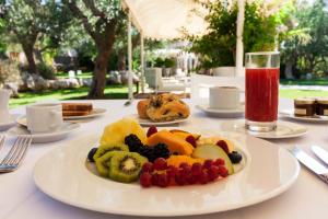 a plate of fruit on a table with a drink at Montiro' Hotel in Leuca