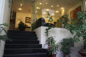 een lobby met trappen en potplanten bij Lotus House in Hanoi