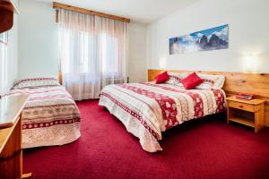 Postel nebo postele na pokoji v ubytování Hotel Coldai + 37 fotografií