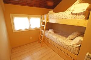 サラルドゥにあるApartamentos SNÖ Mont Romiesのベッドルーム1室(二段ベッド2台、窓付)が備わります。