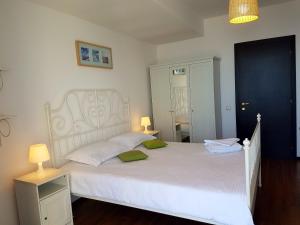 ママイアにあるApartment Summerland Mamaiaのベッドルーム1室(白いベッド1台、緑の枕2つ付)